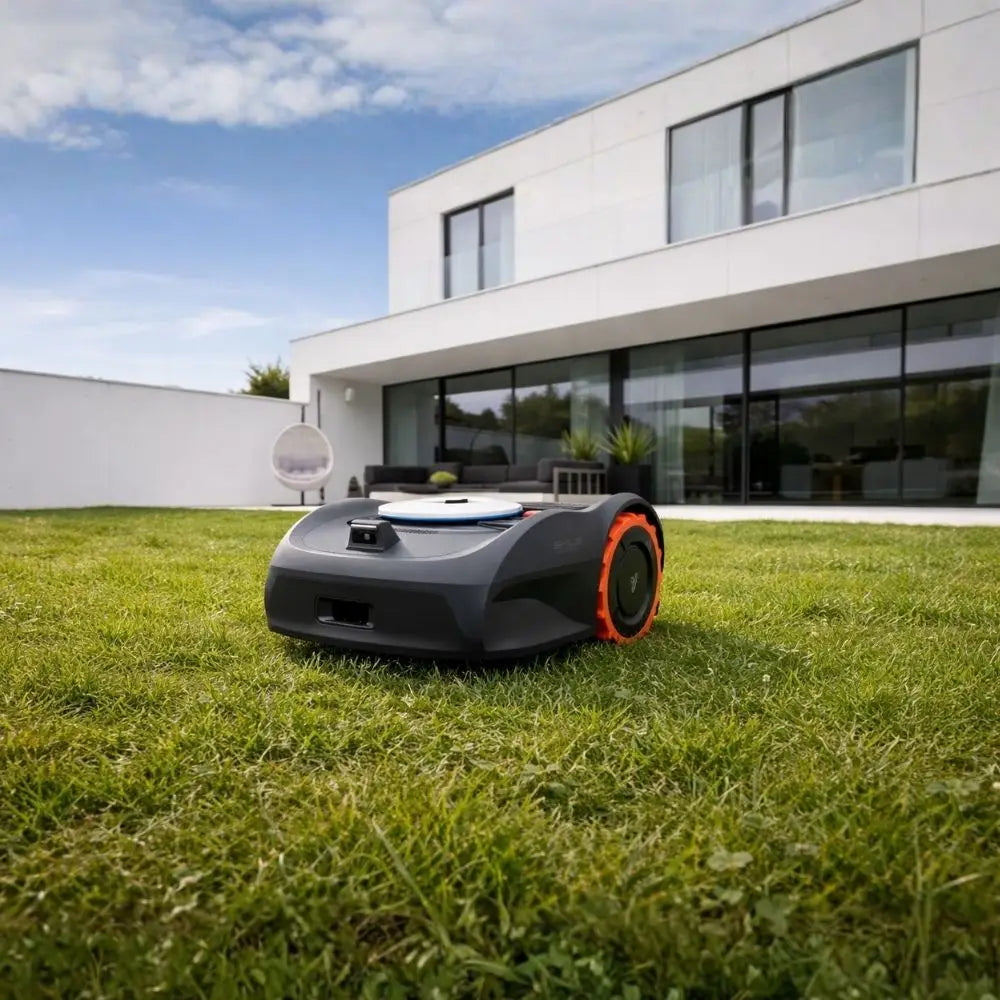 Robot tondeuse Segway Navimow i108E tondant la pelouse devant une maison